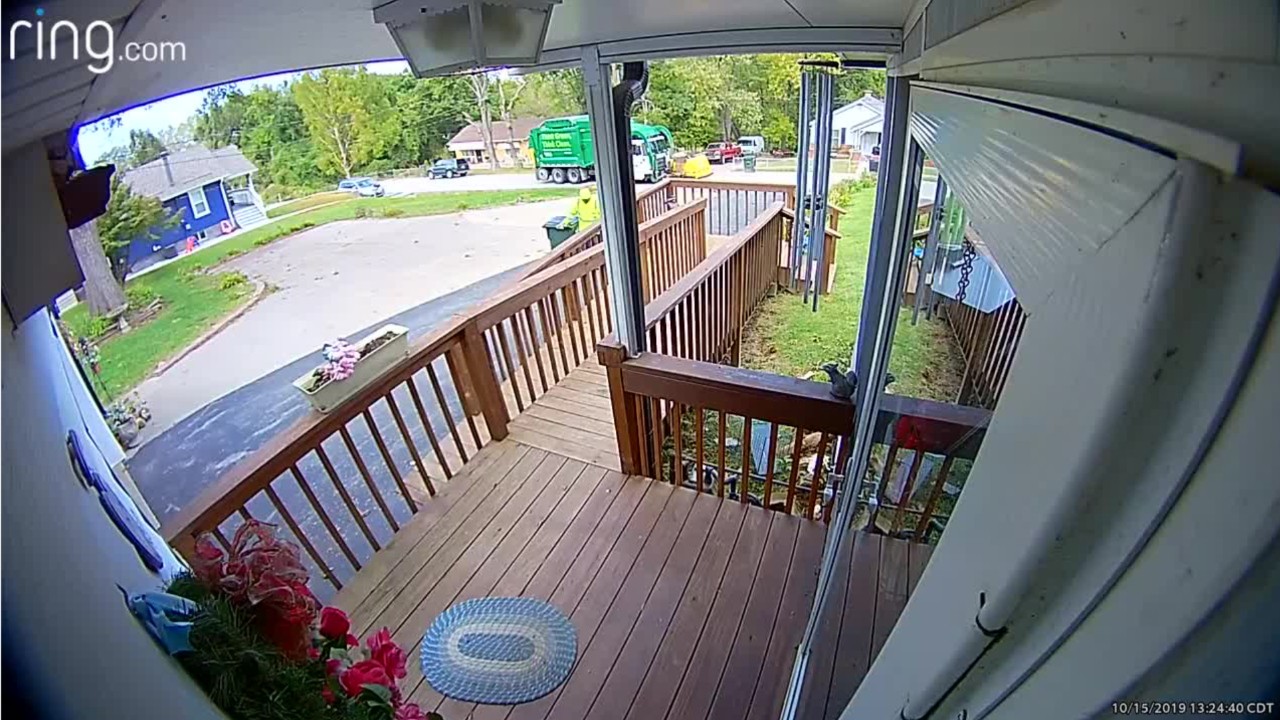 Sanitation worker helps elderly woman up driveway