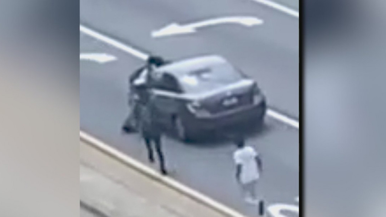 Teens cling to moving car while attempting to sell water