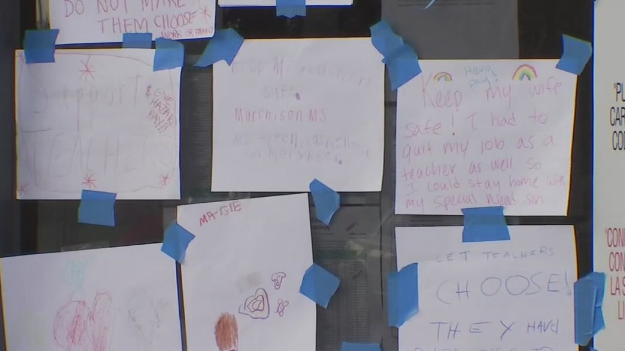 Students tape signs demanding action to front of Austin ISD HQ