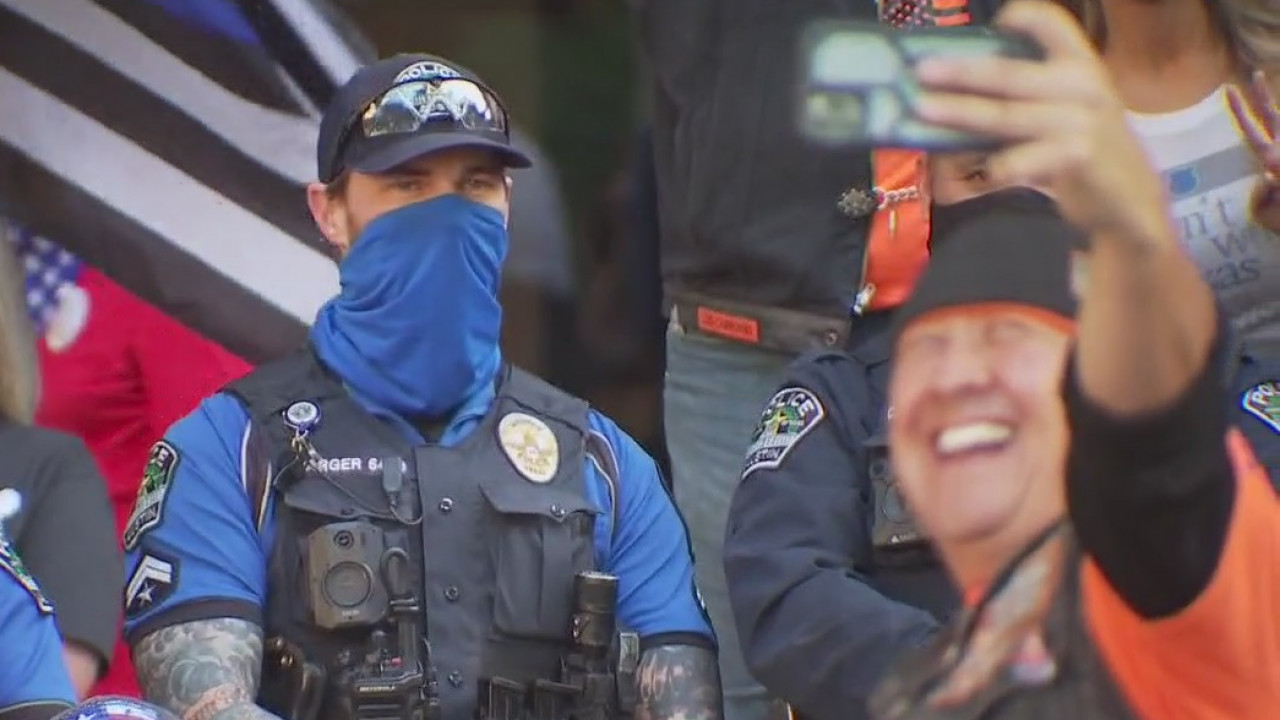 APD officers appear to take photo with protesters using white power signs