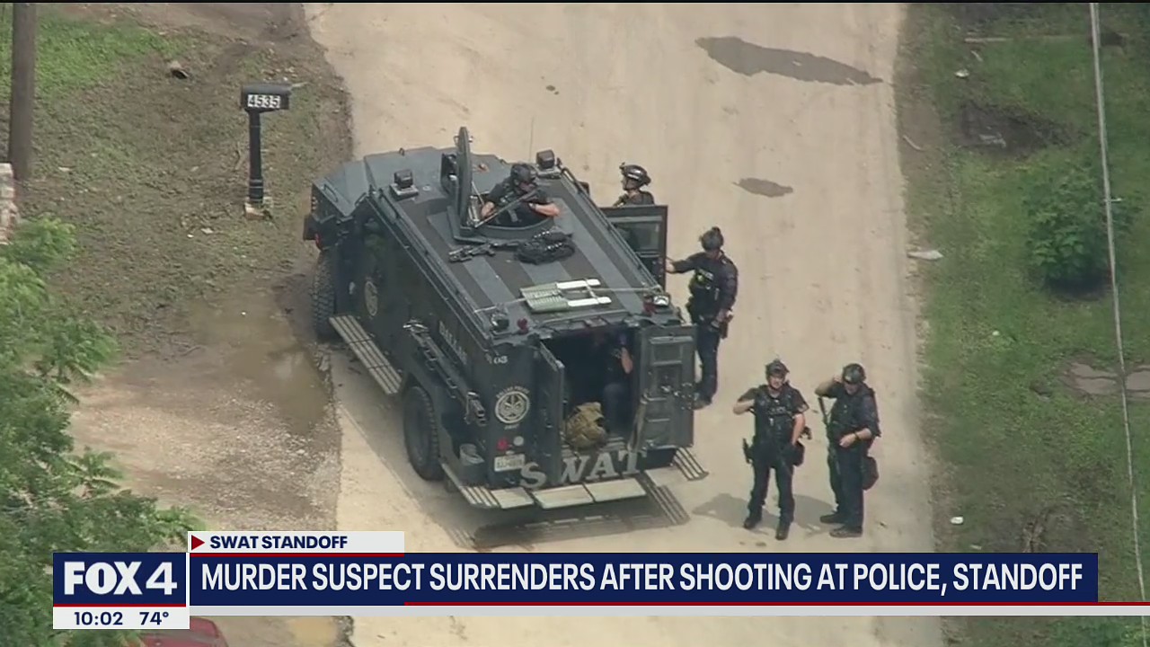 Murder suspect surrenders after shooting at police, hours-long standoff