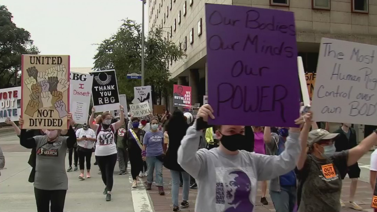 Women march through the streets in Downtown Houston