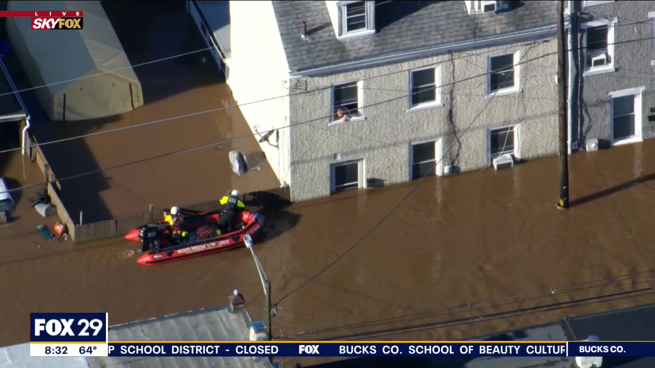 Rescue crews attempt to save residents trapped by floodwaters