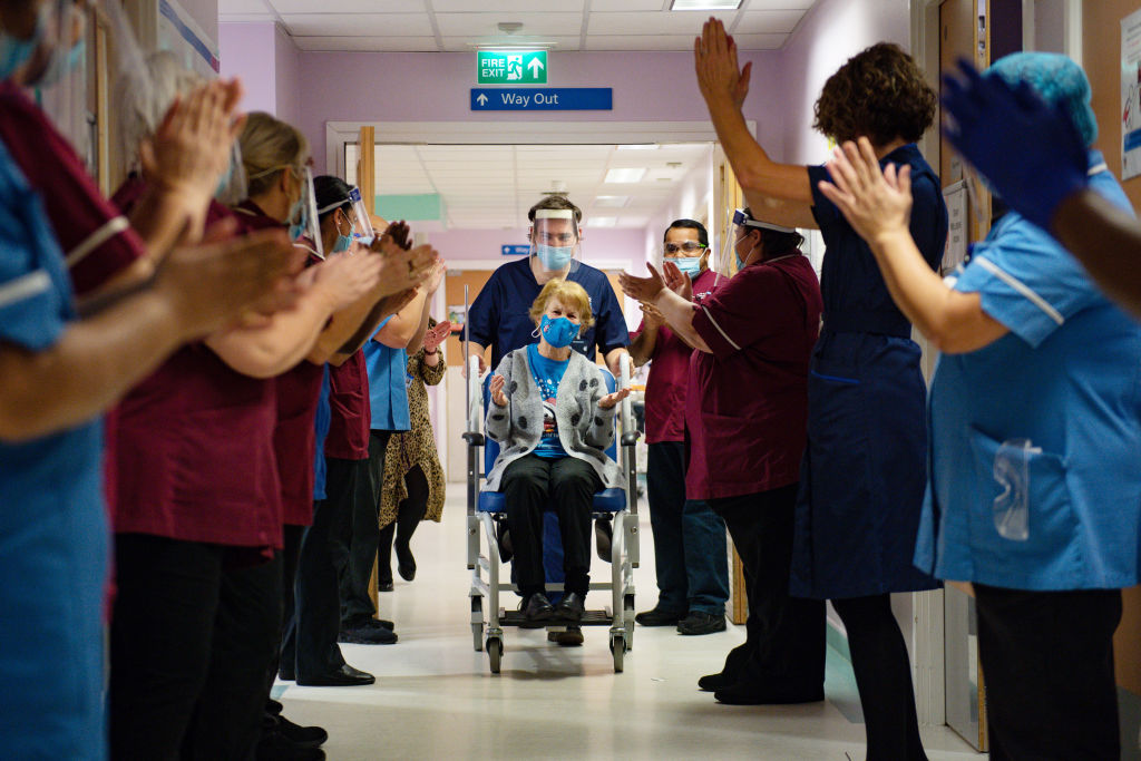 NHS staff applaud first recipient of approved coronavirus vaccine