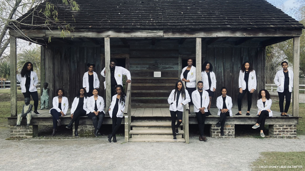 Black Tulane med students take photo in front of former slave quarters