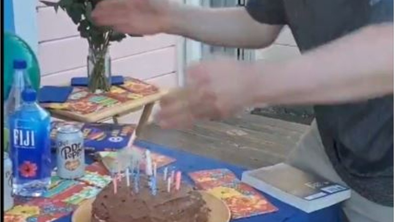 Germ conscious man uses hands to blow out candles
