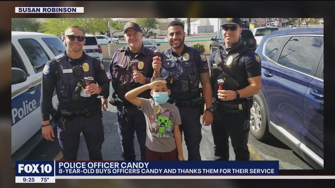 Boy gifts officers candy with toy police cars on top to show appreciation