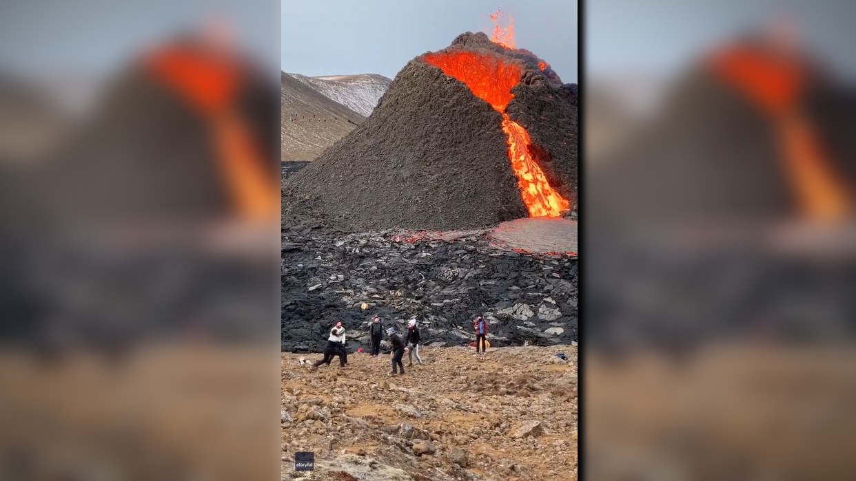 Group plays volleyball near erupting volcano